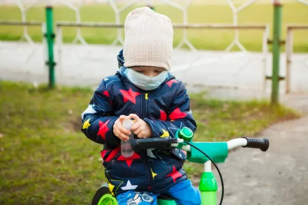 nino-paseo-parque-ciudad-mascara-medica-bicicleta-tratamiento-manos-antiseptico-caminando-calle-periodo-cuarentena-pandemia-coronavirus-mundo_90756-441